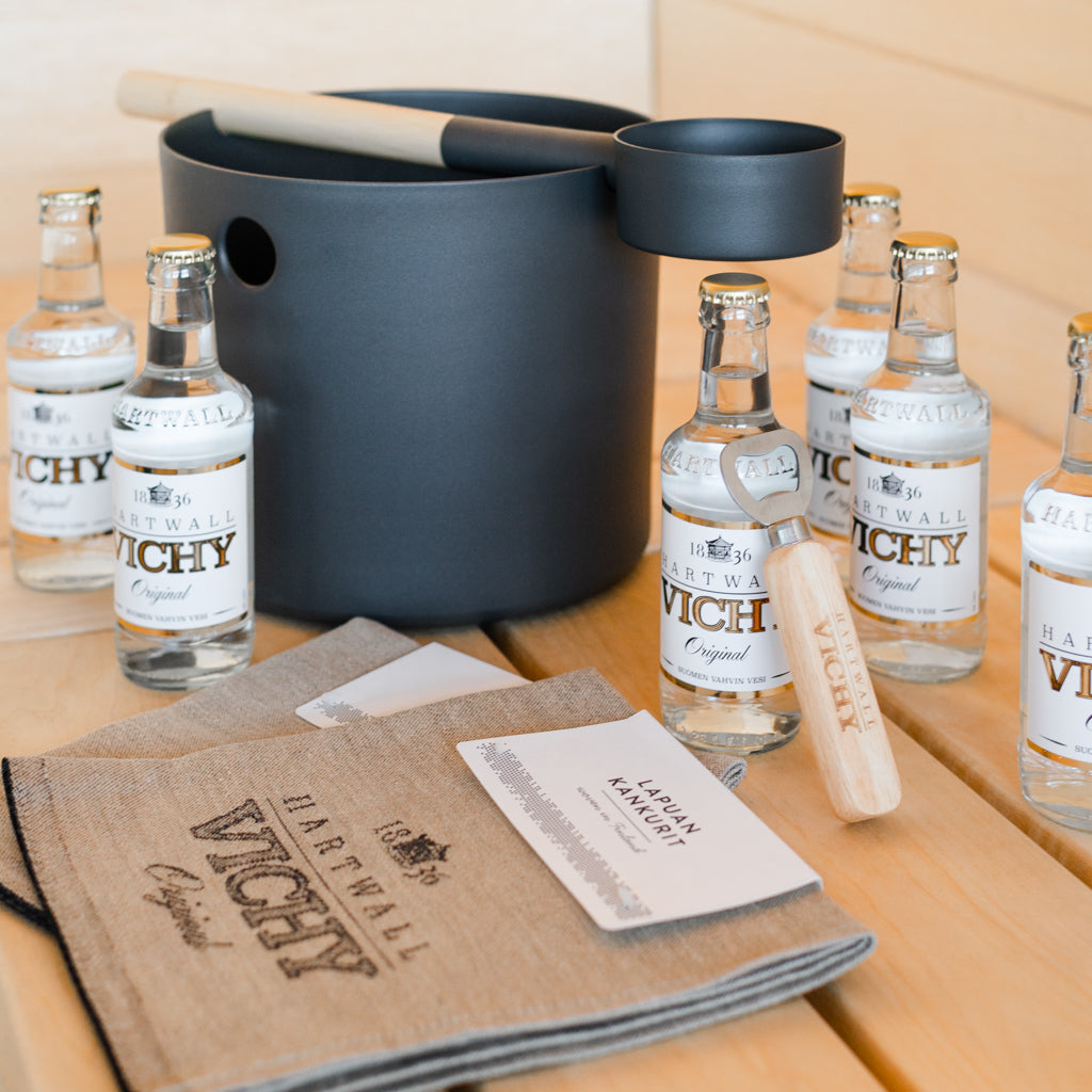 6 kpl Hartwall Vichy Original 0,25 l lasipulloja, pullonavaaja, kaksi Hartwall Vichy x Lapuan Kankurit -laudeliinaa ja Hartwall Vichy Kolo Kiulu + Kauha